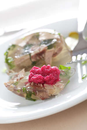 Beef tongue in aspic on white plate closeupの写真素材