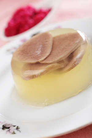 Beef tongue in aspic on white plate closeupの写真素材