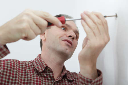 Worker twisting the scriew in the wallの写真素材