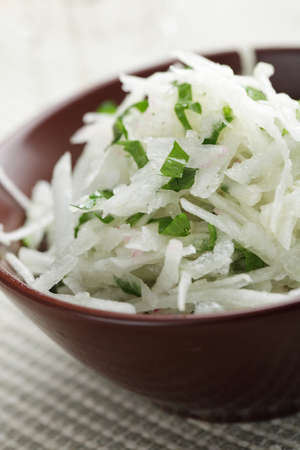 Radish and green onion salad in the brown bowlの写真素材