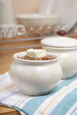 Pot with hot kasha, buckwheat porridge with a cube of butterの写真素材