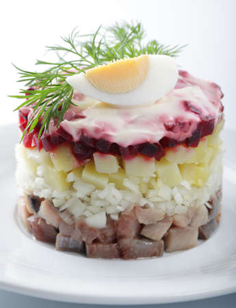 Russian herring salad with potatoes and beetroot on the white plate closeupの写真素材