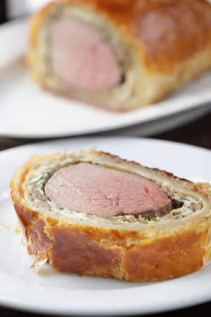 Slice of rare Beef Wellington on the plate closeupの写真素材