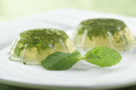 Mint jelly on the plate with fresh leaf of peppermint. Shallow DOF