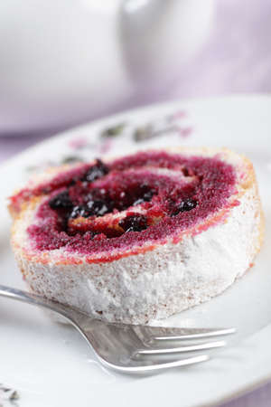 Slice of Swiss roll with black currant jamの写真素材
