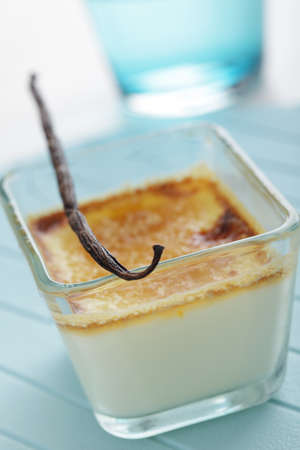 Creme brulee in the glass dish with vanilla stickの写真素材