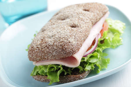 Sandwich with rye bread, ham, and vegetablesの写真素材