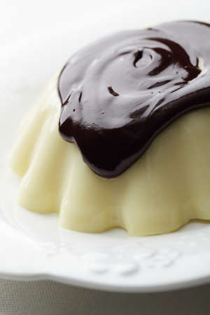 Vanilla pudding with chocolate topping on the white plateの写真素材