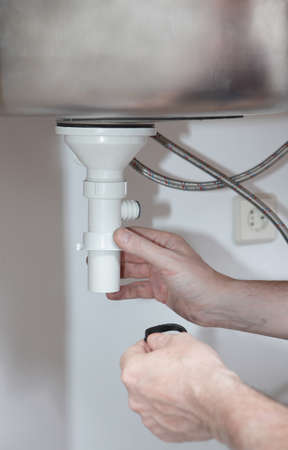 Plumber installing the drain for the kitchen sink