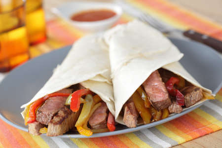 Beef steak burritos with vegetables on the plateの写真素材