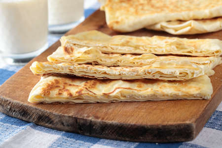 Slices of gozleme with cheese on a cutting board
