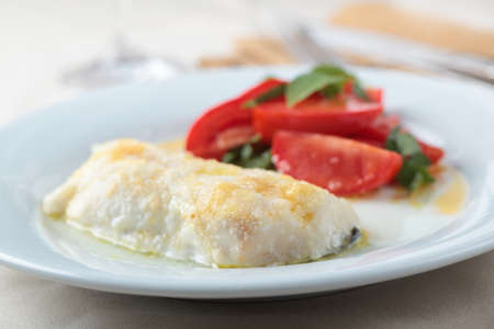 Baked cod fillet with tomato and basil saladの写真素材