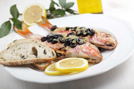 Baked goatfishes with olives, lemon, and ciabattaの写真素材
