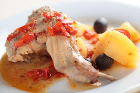 Baked rabbit with olives, pepper, and potatoの写真素材
