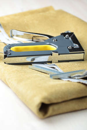 Upholstery stapler on a piece of fabric