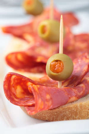 Canapes with chorizo and green olives stuffed with paprika