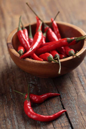 Red chili peppers in a wooden bowlの写真素材