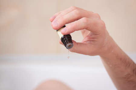 Adult man having a bath with essential oilの写真素材