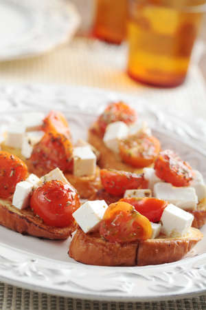 Crostinis with diced feta cheese and cherry tomatoの写真素材