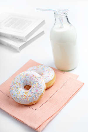 Two dunuts with prinkles and a bottle of milkの写真素材