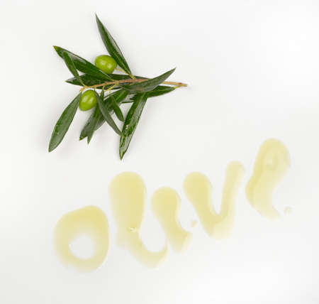 Branch with olives and olive oil wordの写真素材