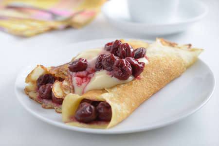 Crepes with vanilla custard and cherryの写真素材