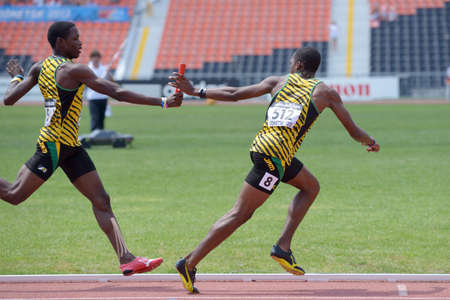 Donetsk, Ukraine - July 13, 2013: Devaughn Baker pass the baton to Martin Manley, Jamaica, in the boys medley relay during World Youth Championships in Donetsk, Ukraine on July 13, 2013のeditorial素材