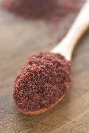 Sumak in a wooden spoon  Selective focus on the spice