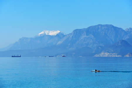 Bathing in the Mediterranean sea against snowy mountains near Antalya, Turkeyの写真素材