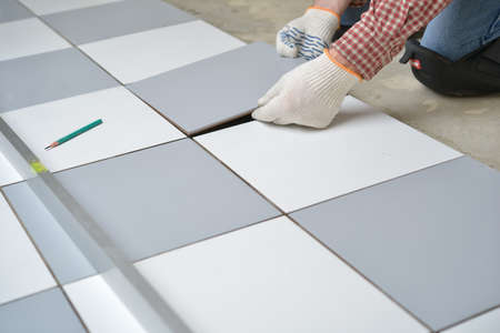 Tiler install ceramic tiles on a floorの写真素材