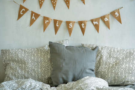 Bedroom with Christmas decorations on the wallの写真素材