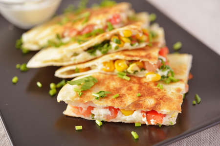 Vegetarian quesadilla with sour cream. Selective focus on the front wedgeの写真素材
