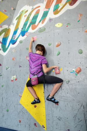 Dnepropetrovsk, Ukraine - April 11, 2015: Girl trains during the open bouldering festival Dnepr Montana Kids. The festival organized by the climbing wall Montana and the local association of extreme sportsのeditorial素材
