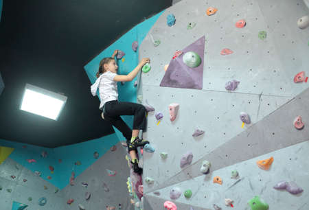 Dnepropetrovsk, Ukraine - April 11, 2015: Girl trains during the open bouldering festival Dnepr Montana Kids. The festival organized by the climbing wall Montana and the local association of extreme sportsのeditorial素材