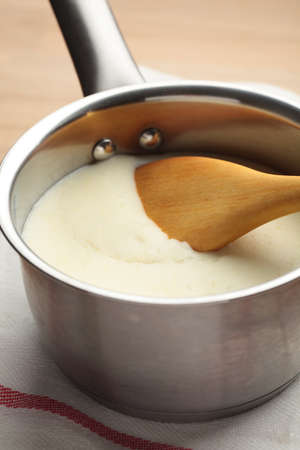Bechamel in a sauce pan with wooden spoonの写真素材