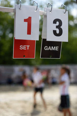 Scoreboard against the people playing beach tennisの写真素材