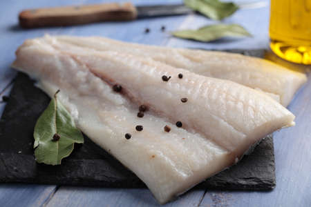 Raw Atlantic halibut fillet on a slate board