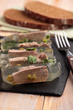 Beef tongue aspic on a slate cutting board