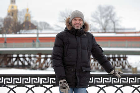 Mature man in winter clothes against St. Peter and Paul fortress in St. Petersburg, Russiaの写真素材