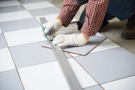 Tiler marks the tile during the floor installationの写真素材