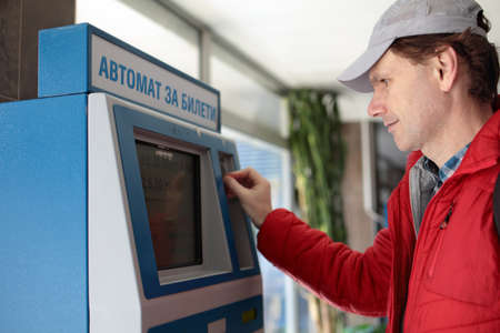 Man buying subway tickets using vending machine in Sofia, Bulgaria