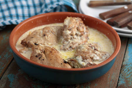 Rabbit under sour cream sauce on a rustic tableの写真素材