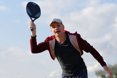 Mature man playing beach tennis on a beachの写真素材