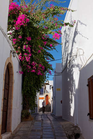 Lindos, Greece - October 9, 2017: People on a narrow street of Lindos. Located 50 km south of the town of Rhodes, Lindos is a popular tourist and holiday destinationのeditorial素材