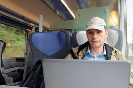 Man working with laptop in a trainの写真素材