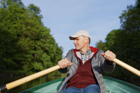Mature man in casual clothes on a rowboat