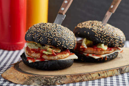 Homemade black hamburgers on a cutting boardの写真素材