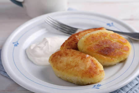 Potato meat filling patties with sour cream on a rustic table