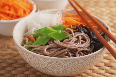Soba noodle soup with nori seaweed sheets, green beans, carrot, and daikon radishの写真素材