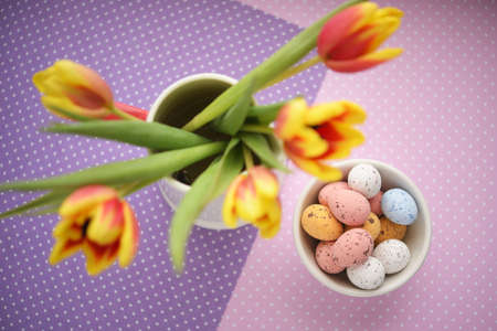 Easter candy egg on with defocused tulips bouquetの写真素材